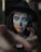 a woman with face paint pointing at the camera