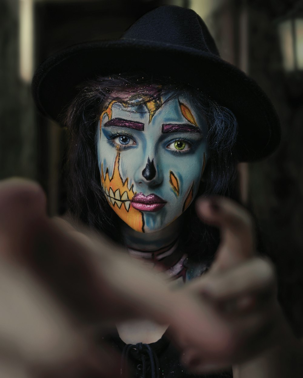 a woman with face paint pointing at the camera