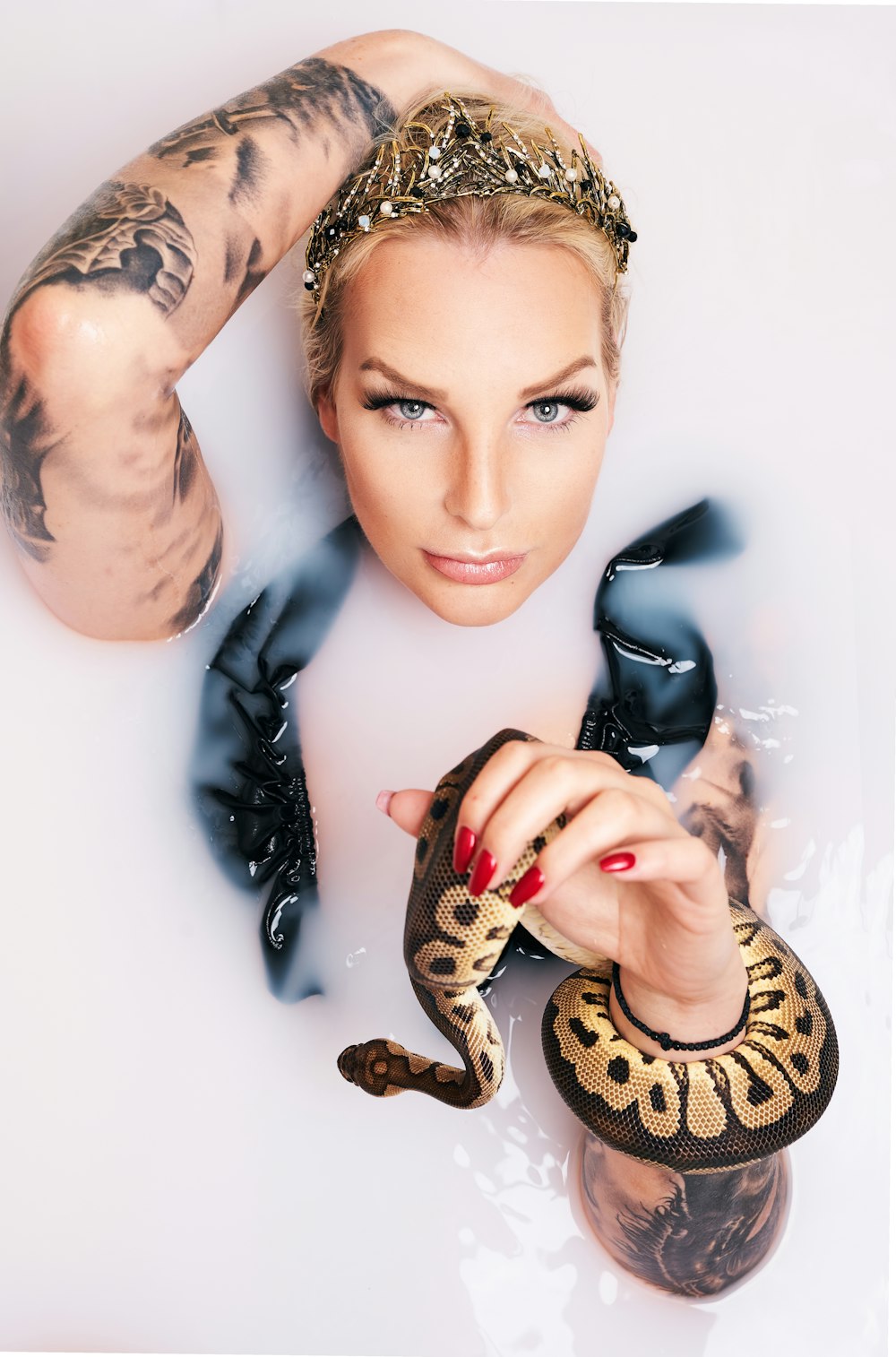 a woman in a bathtub holding a snake