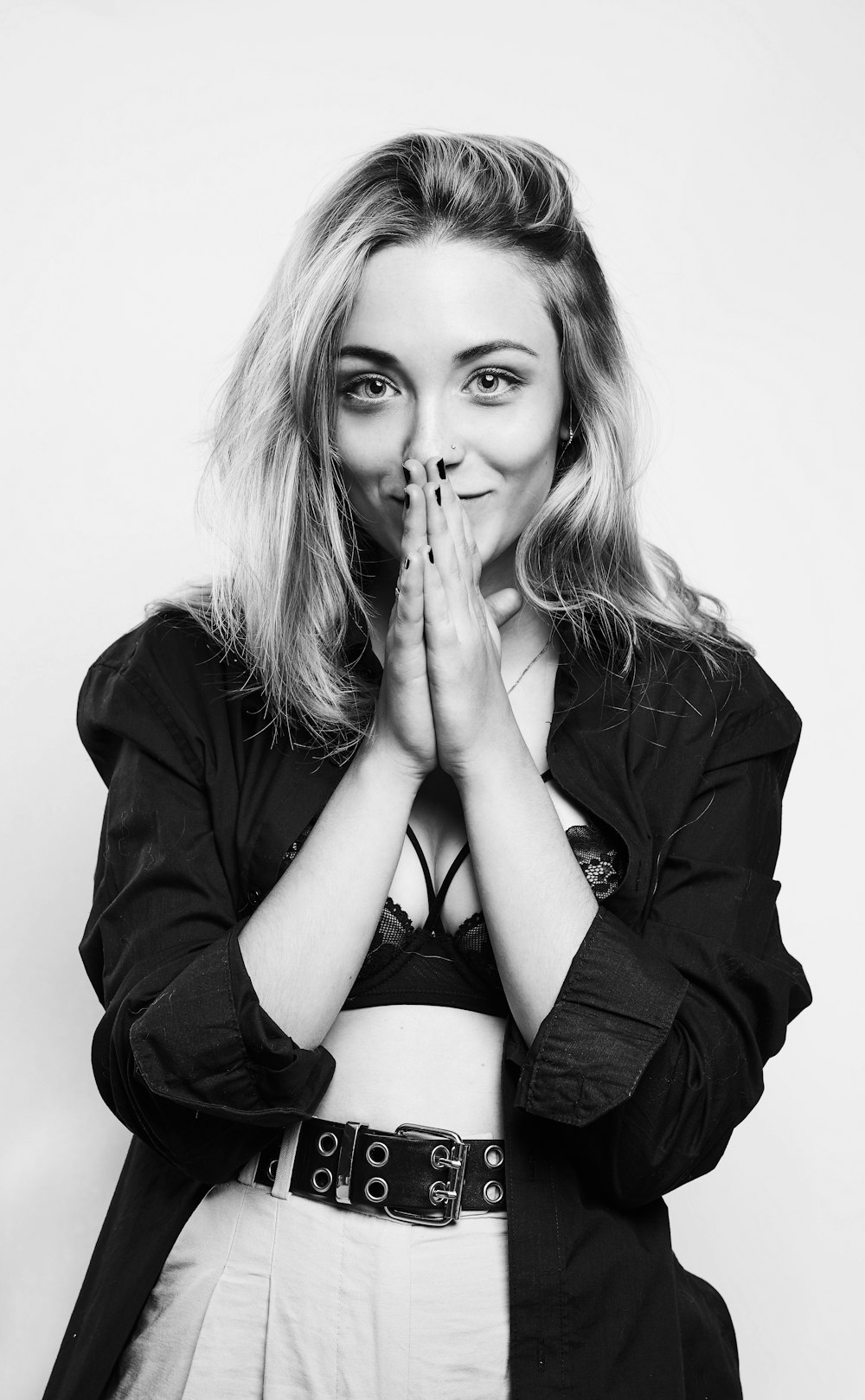 a black and white photo of a woman covering her mouth