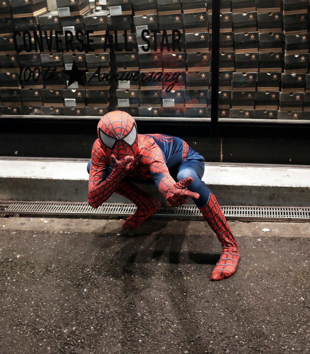 Ein als Spiderman verkleideter Mann hockt