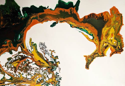 An abstract artwork composed of swirling colors and intricate patterns. Dominant hues include green, orange, and yellow, creating a dynamic and organic flow across the canvas. The paint appears to be marbled, adding texture and depth.
