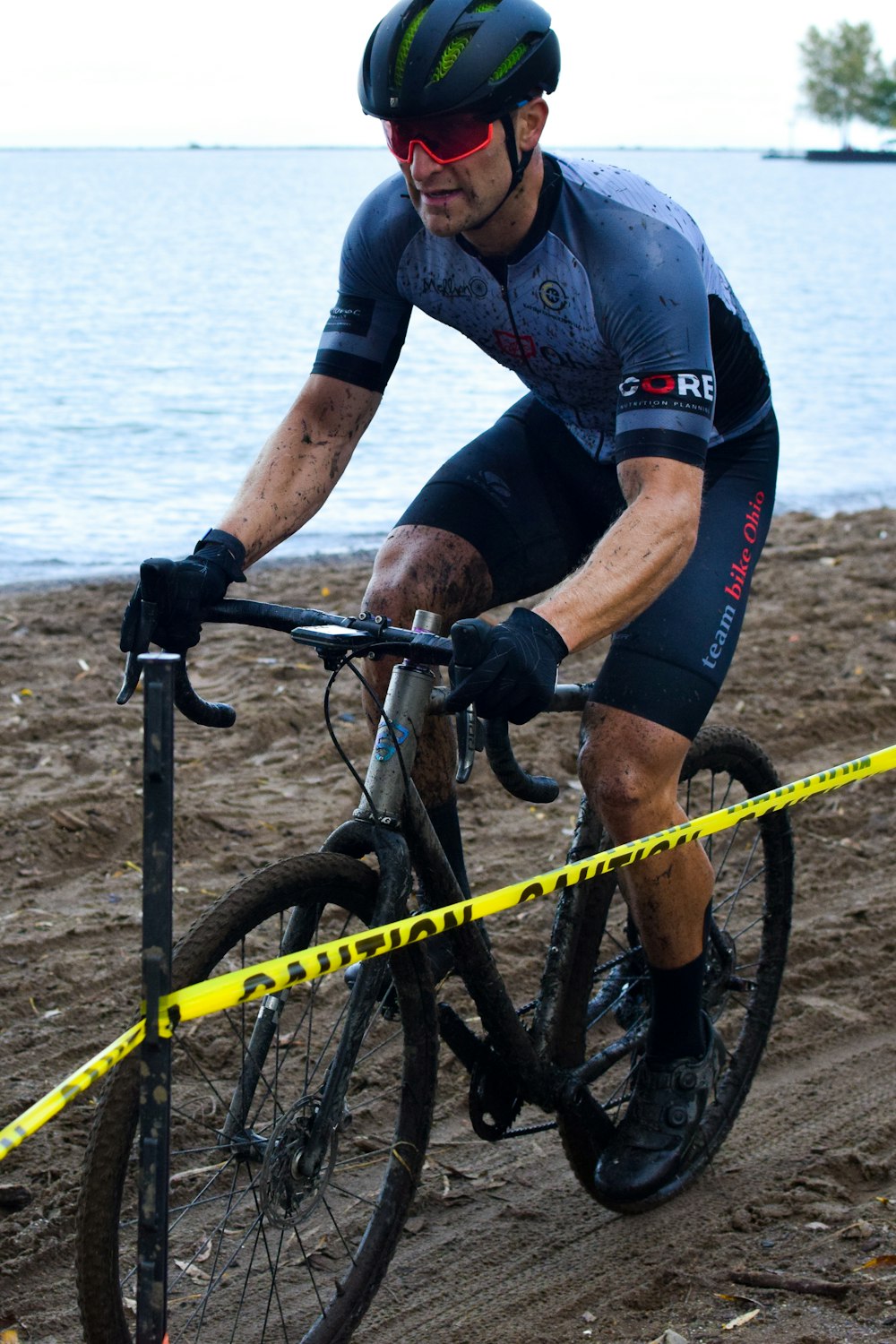 a man riding a bike on top of a sandy beach