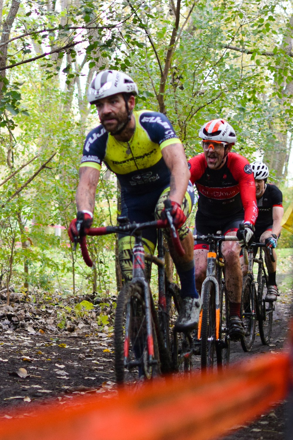 a group of men riding bikes down a dirt road