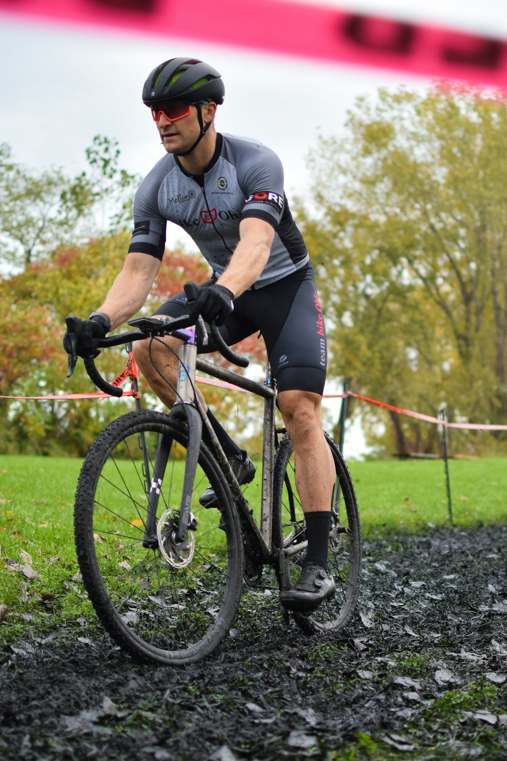 a man riding a bike down a muddy road