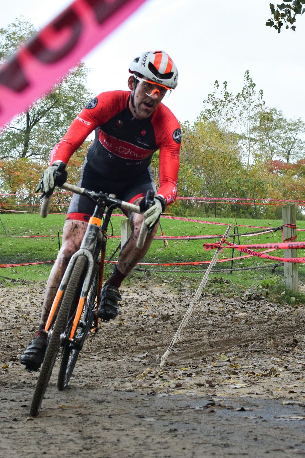 a man riding a bike down a muddy road