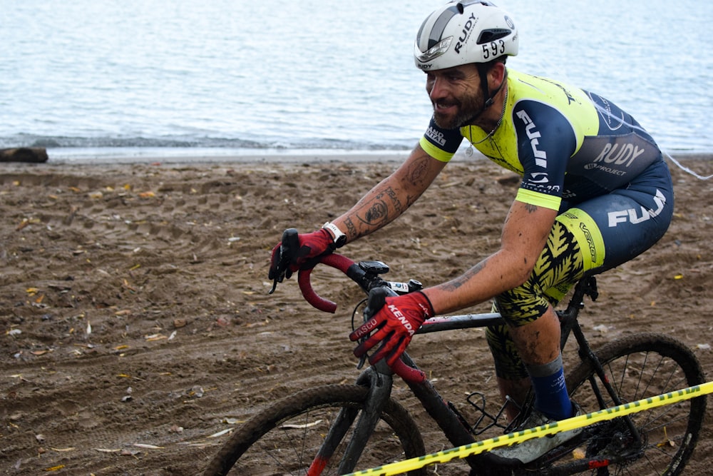 a man riding a bicycle next to a body of water