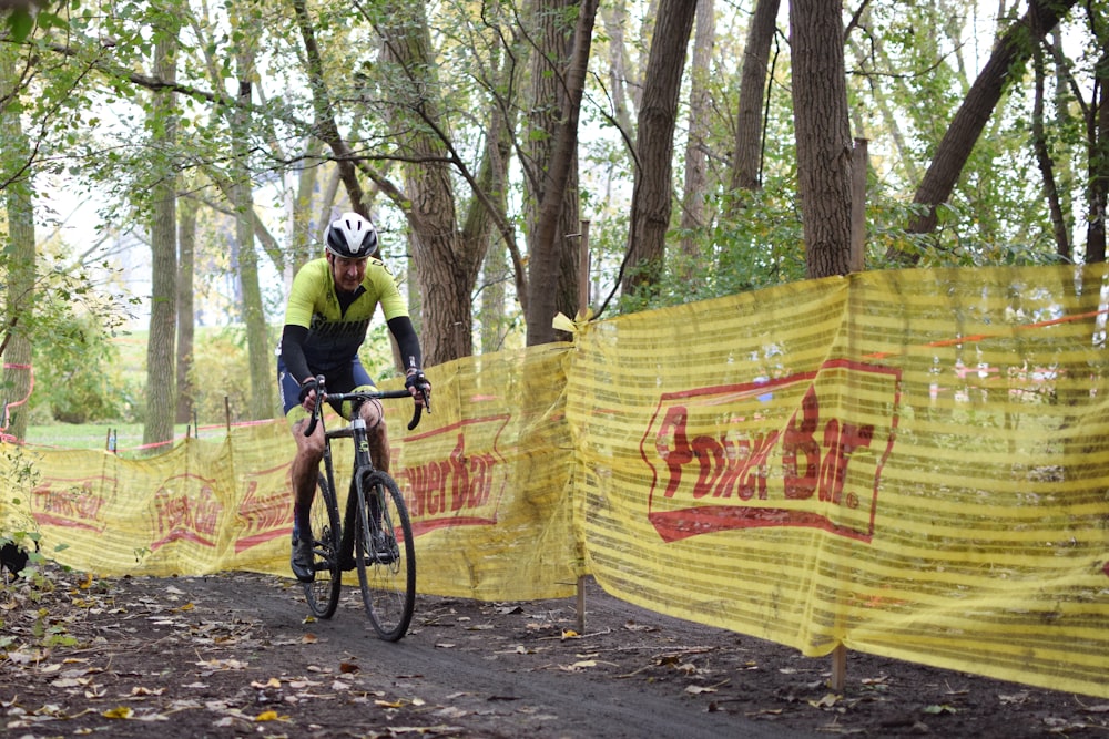 a man riding a bike down a dirt road