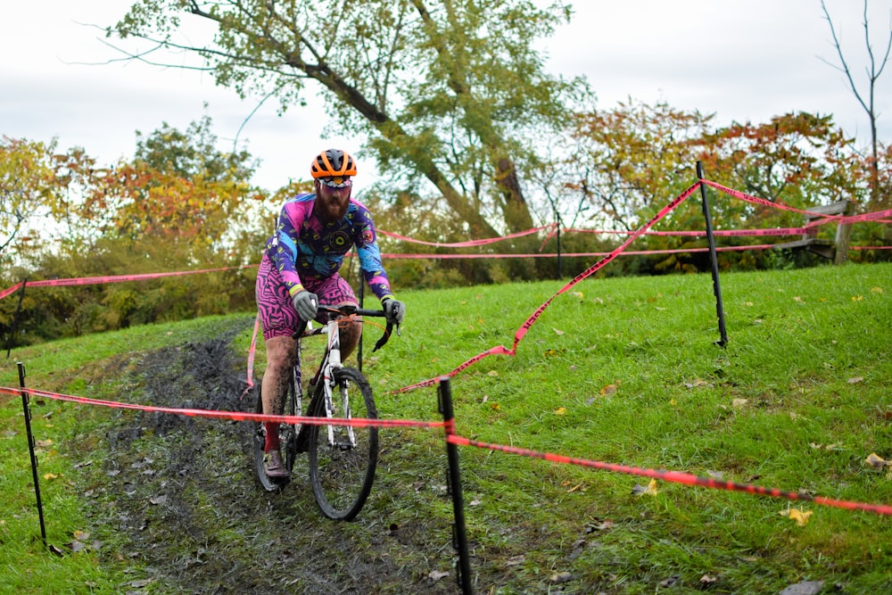 a man riding a bike down a muddy trail