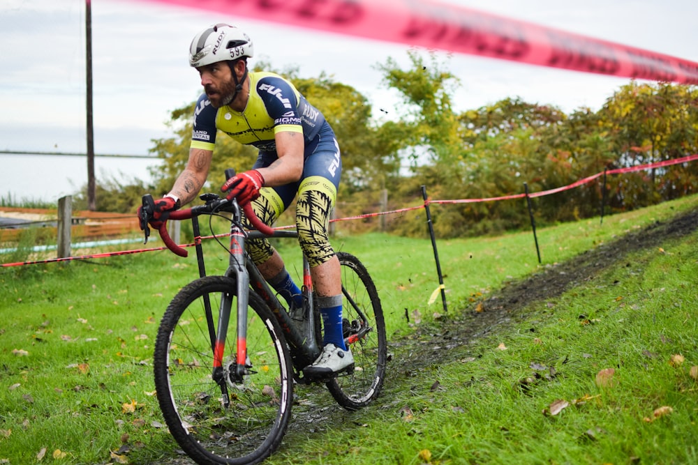 a man riding a bike down a lush green hillside