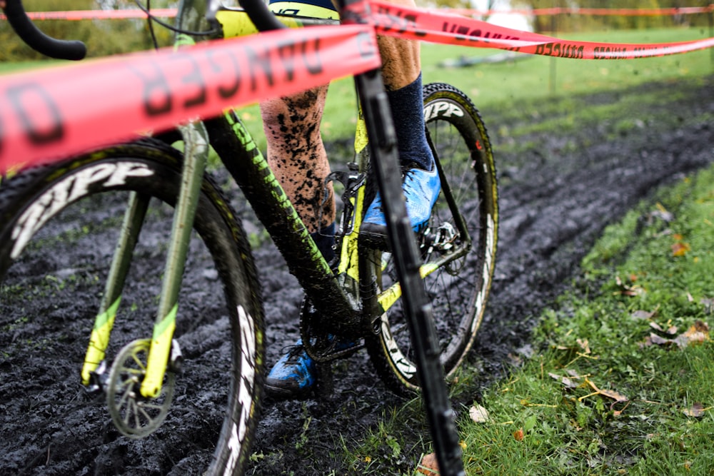 a man riding a bike down a muddy road