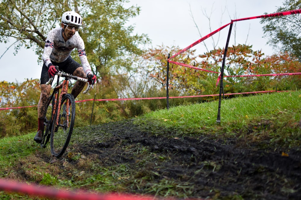 a man riding a bike down a dirt road