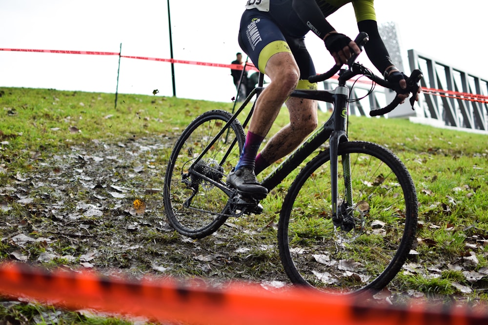 a man riding a bike down a muddy road