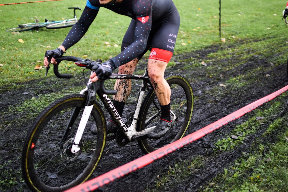 a man riding a bike down a muddy road