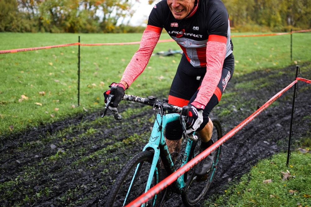 a man riding a bike down a muddy road