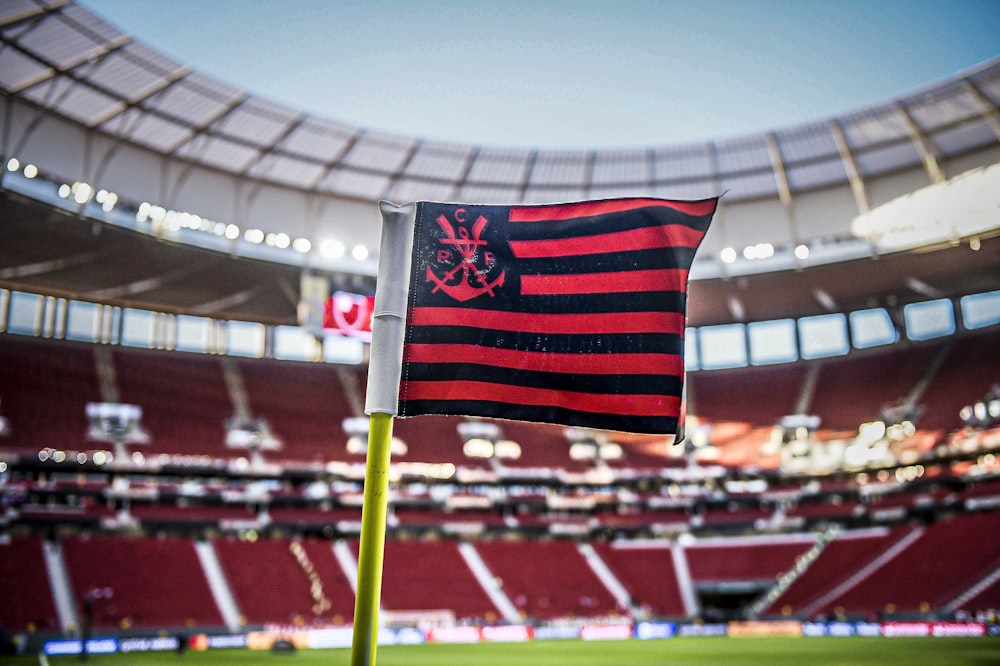 uma bandeira listrada vermelha e preta em um estádio