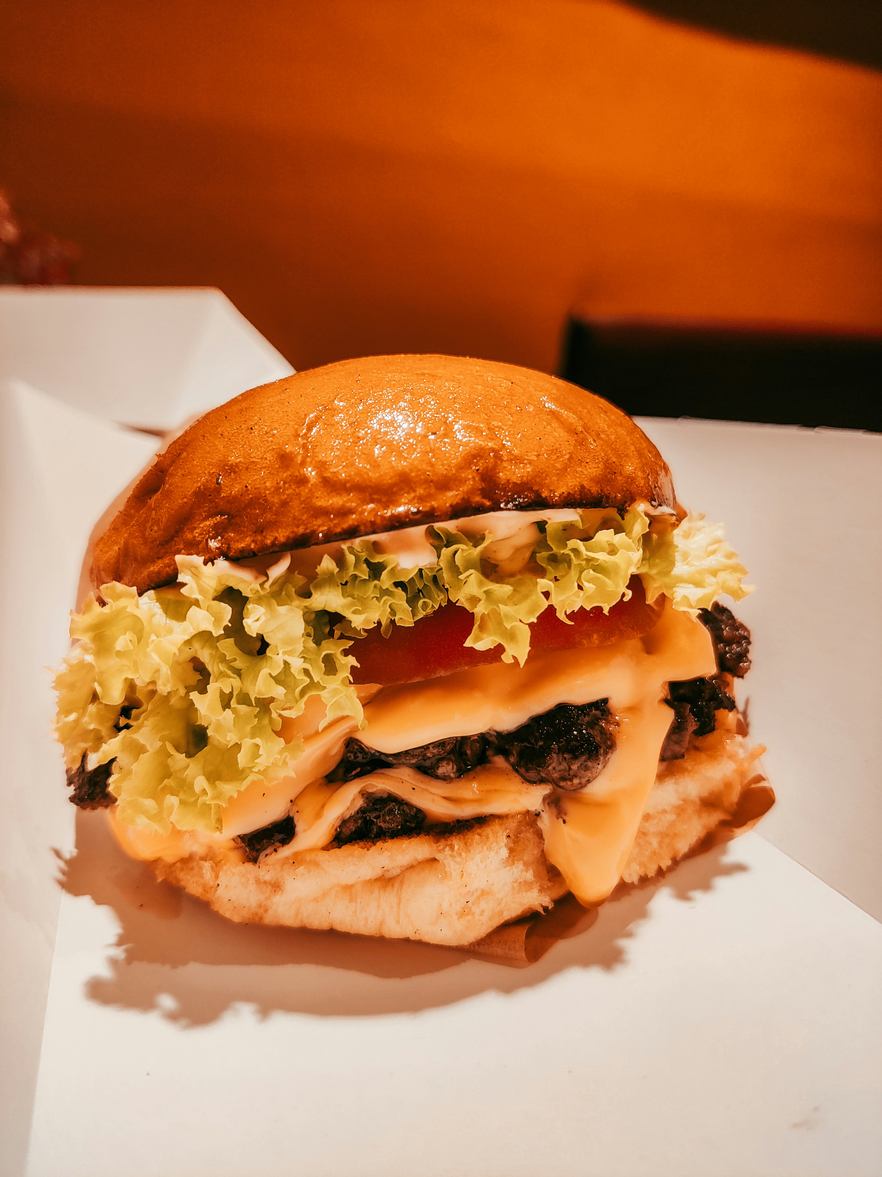 burger keju dengan selada dan tomat di atas gulungan
