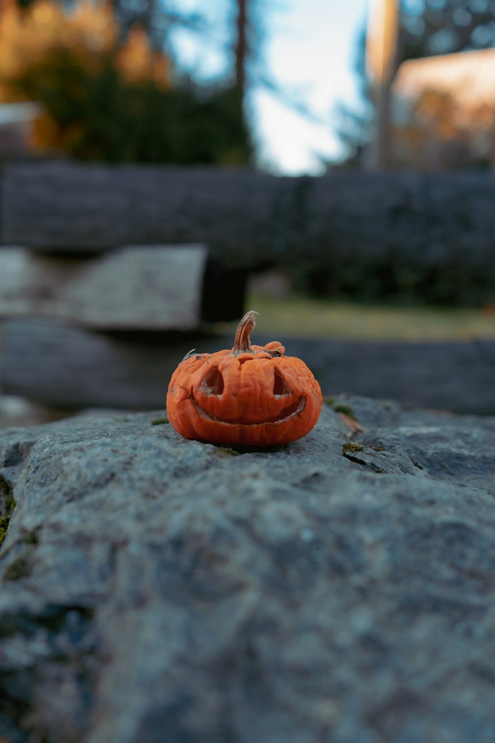 a carved pumpkin sitting on top of a rock