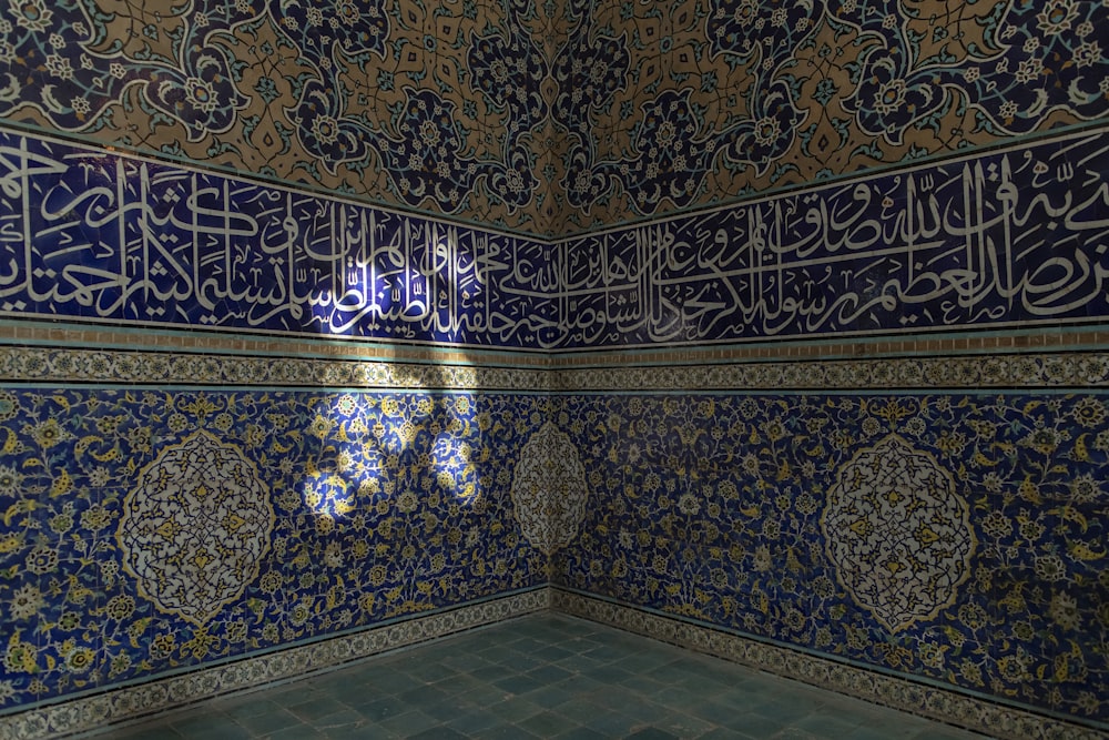 a room with blue and gold tiles and a window