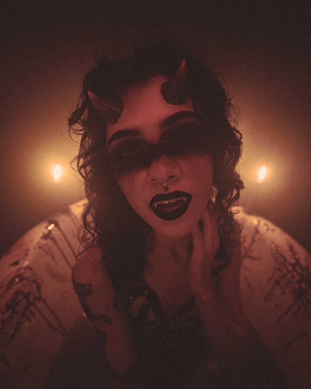 a woman with black makeup and horns on her face
