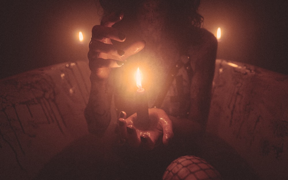 a person holding a lit candle in their hand