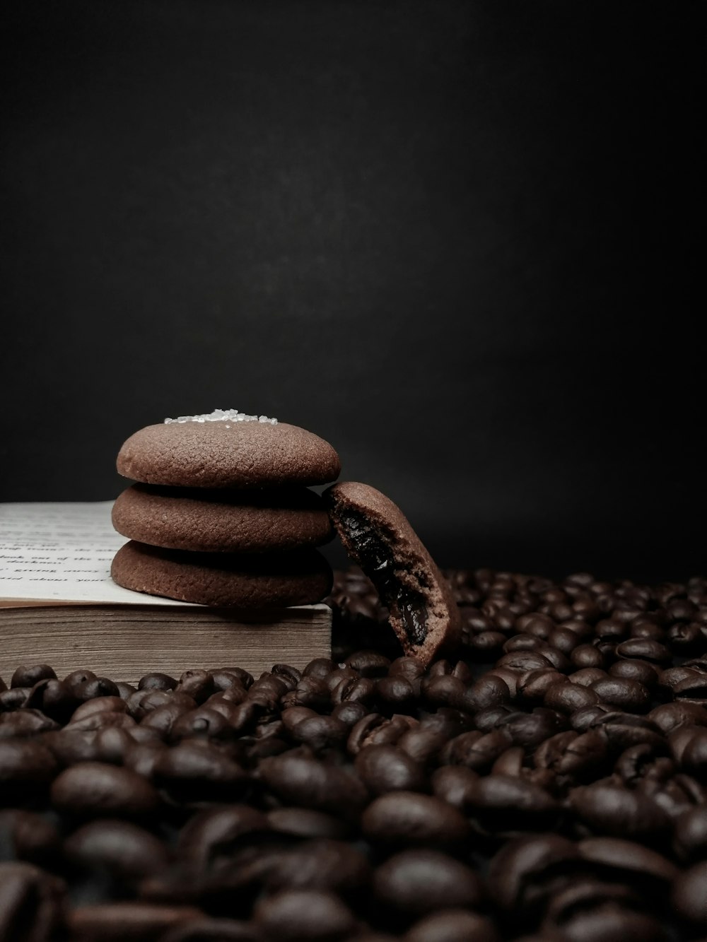 a stack of chocolate cookies sitting on top of a pile of coffee beans
