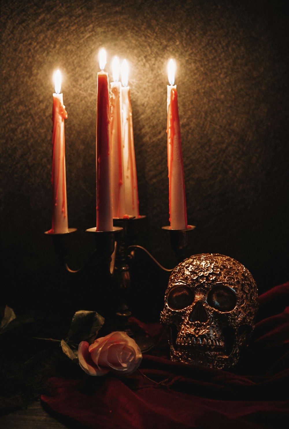a skull sitting next to three candles on a table