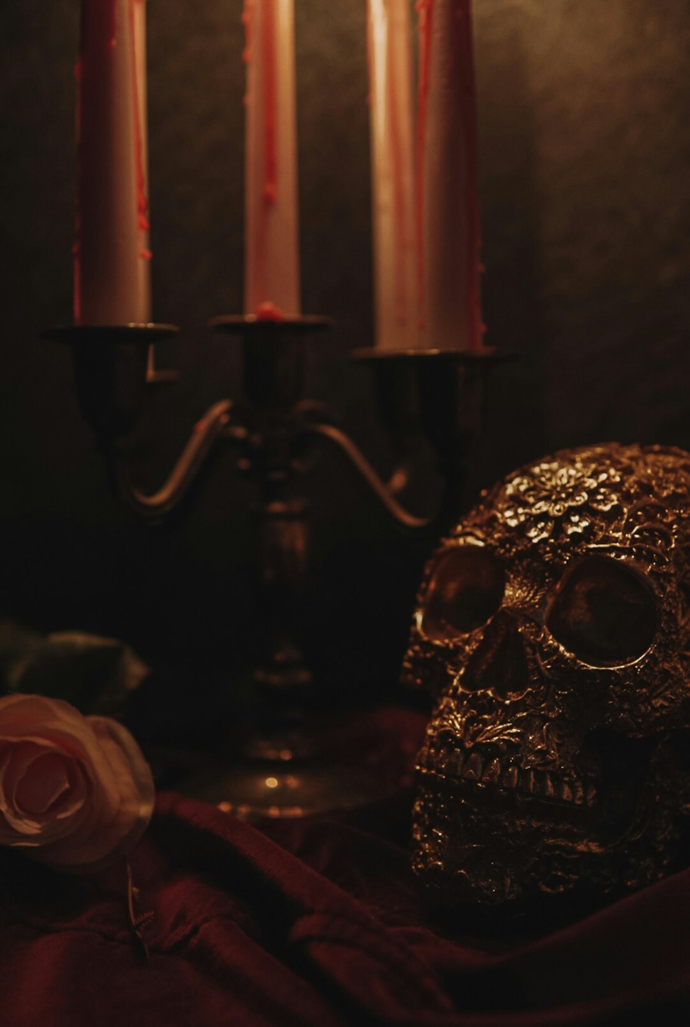 a skull sitting next to two candles on a table
