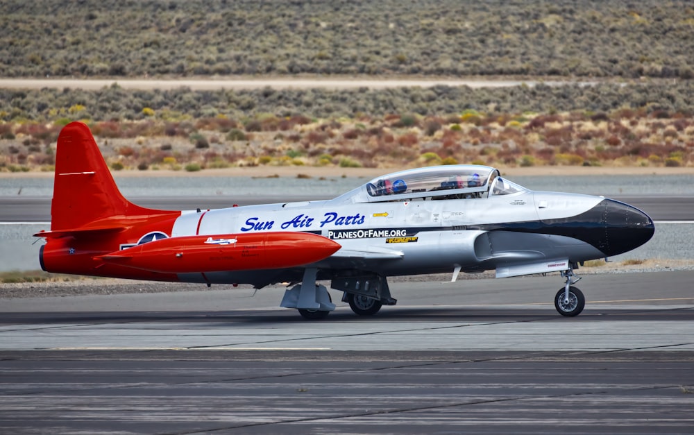 Un avion rouge et blanc est sur une piste