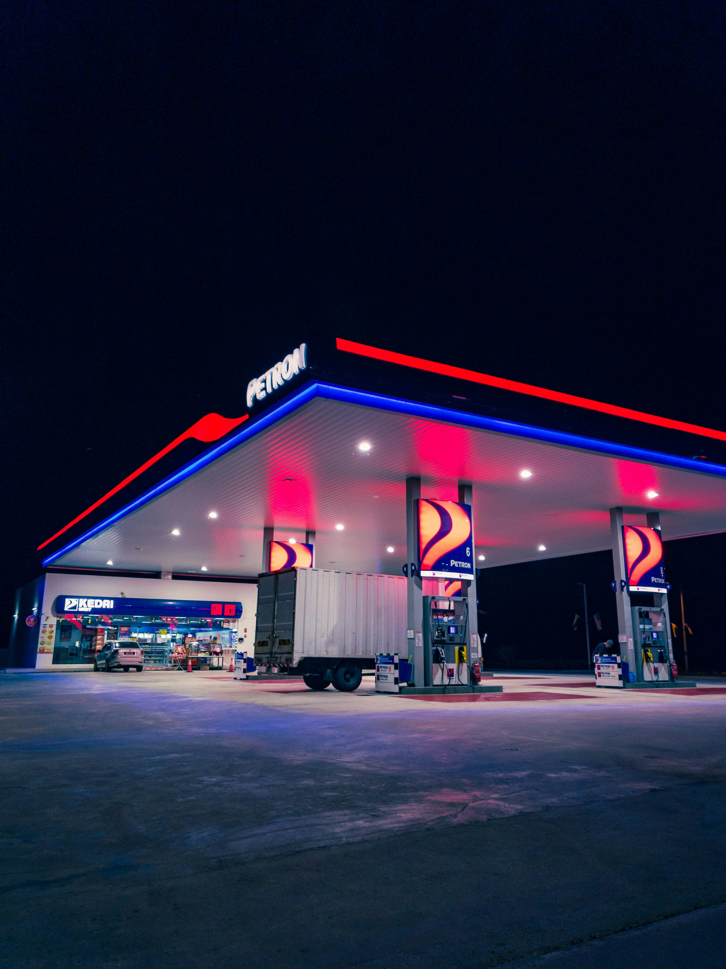 a gas station lit up with red, white and blue lights