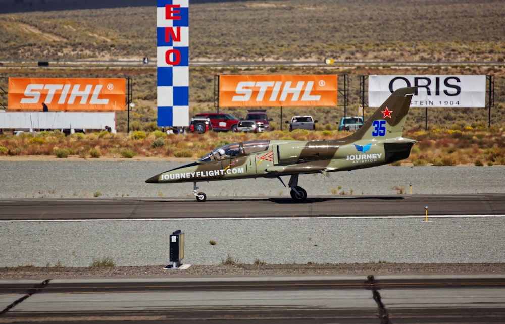 a small green airplane on a run way