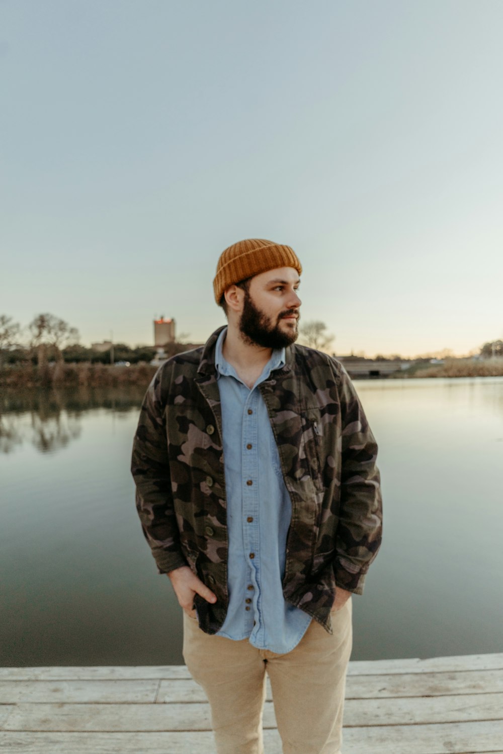 a man standing on a dock next to a body of water