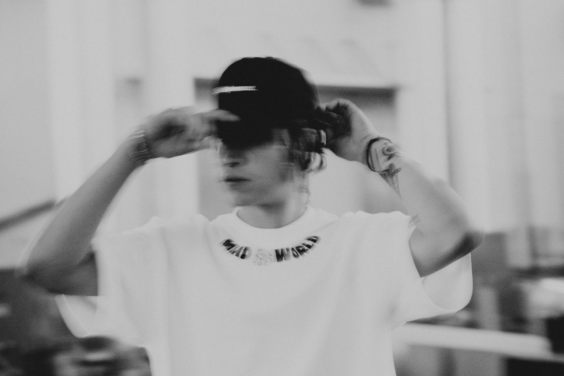 a woman in a white shirt is holding her hair