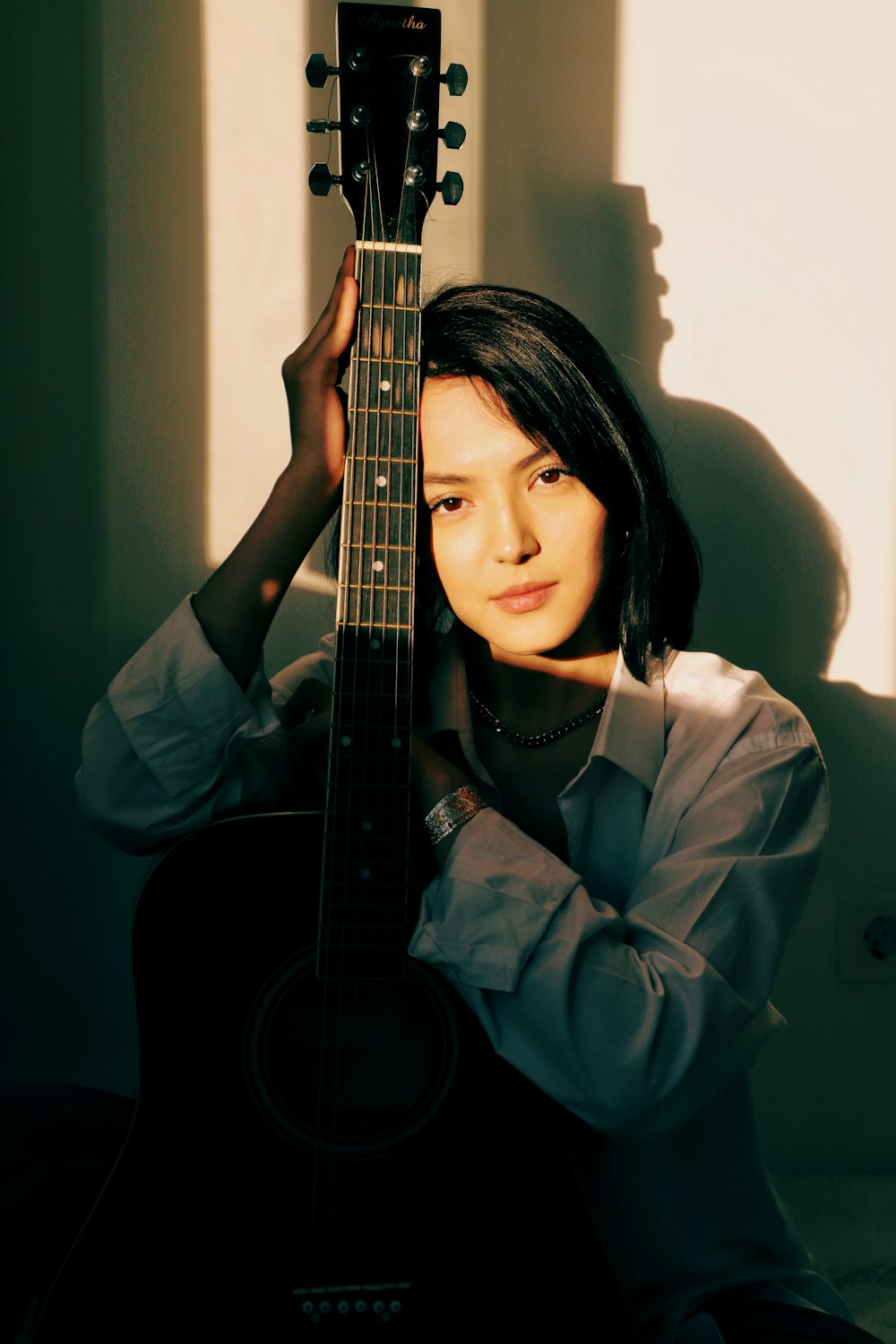 a woman holding a guitar in front of her face