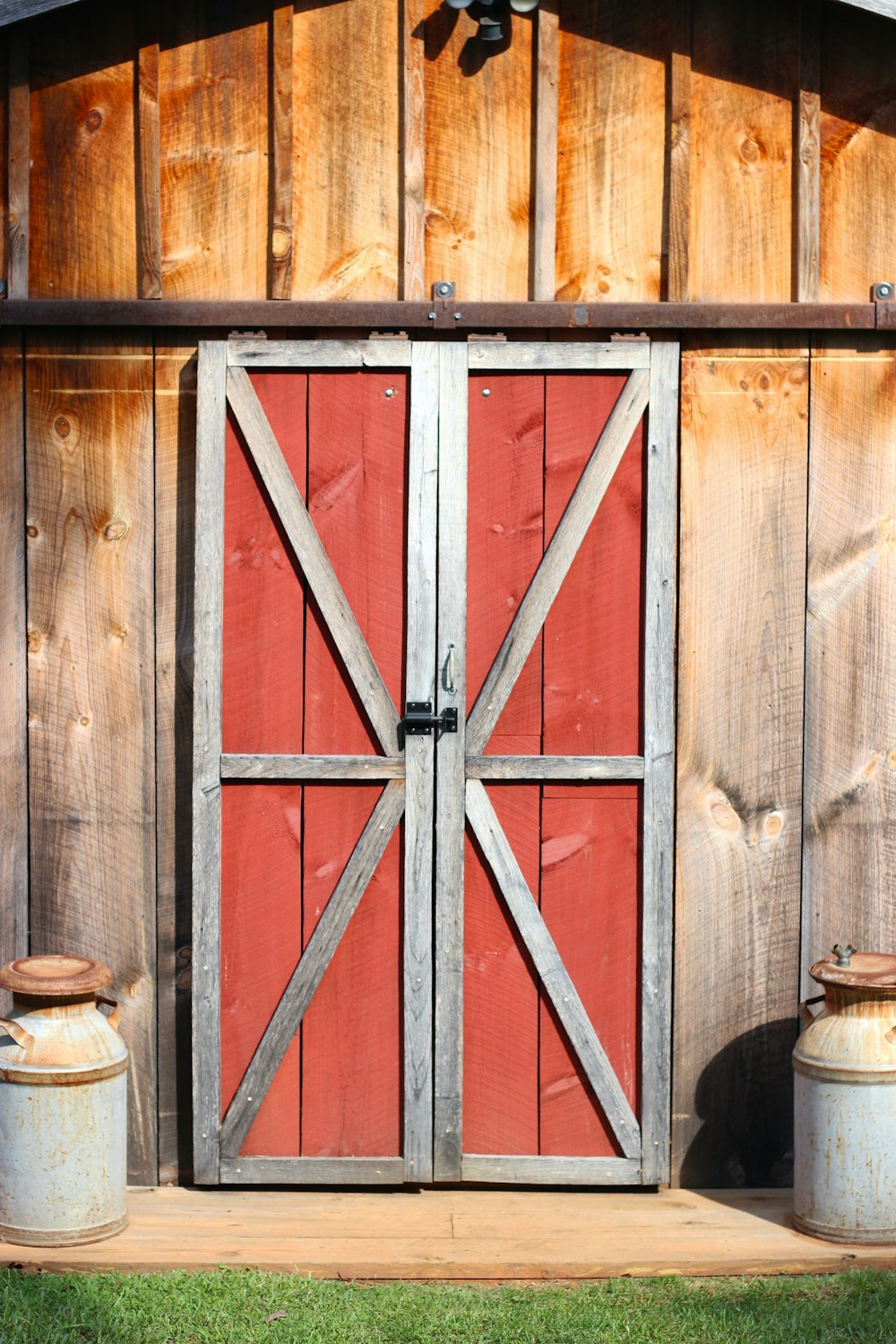 a red barn door with two buckets in front of it