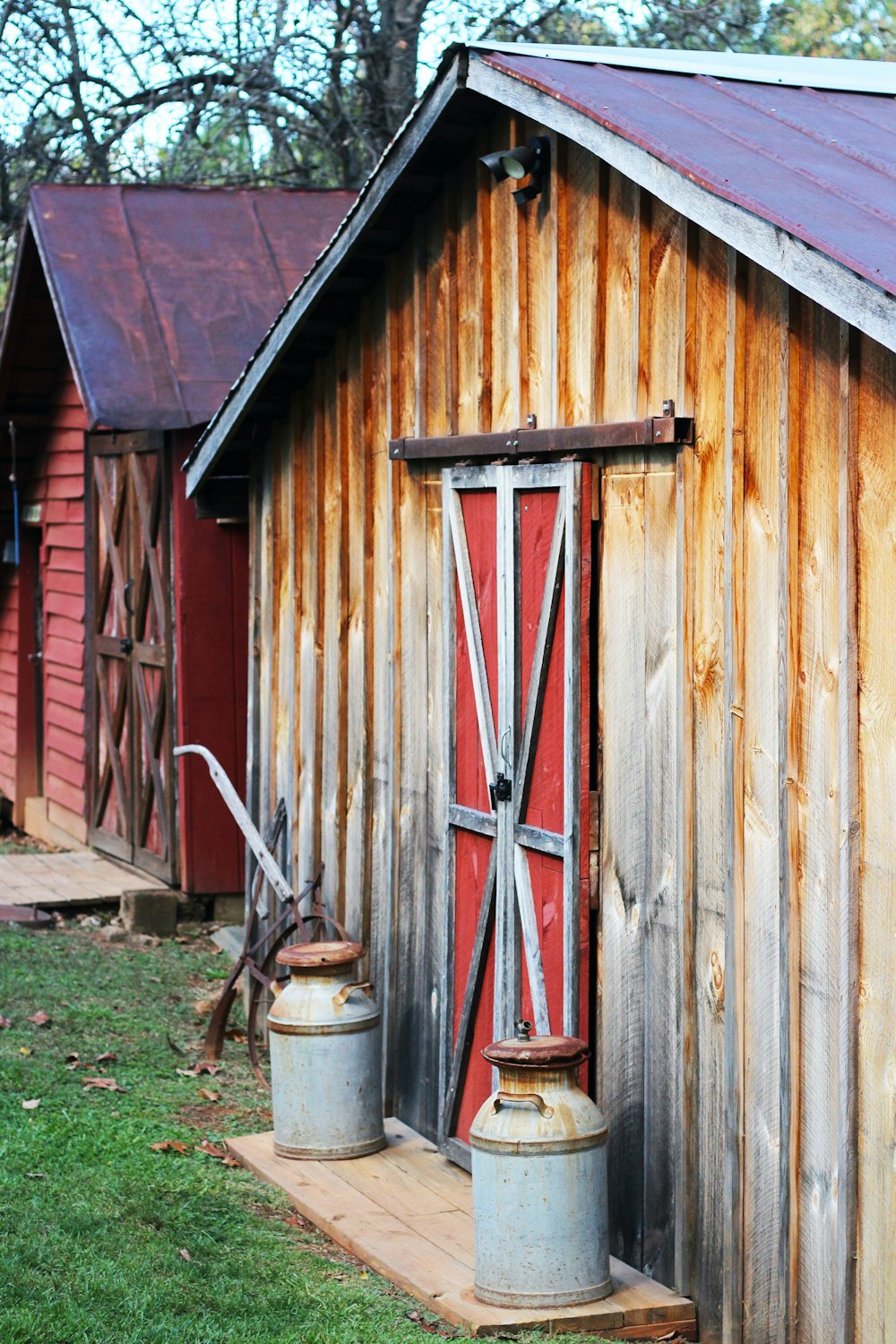 a barn with a red door and two buckets