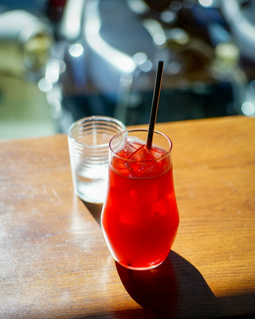 a red drink with a straw sitting on a table