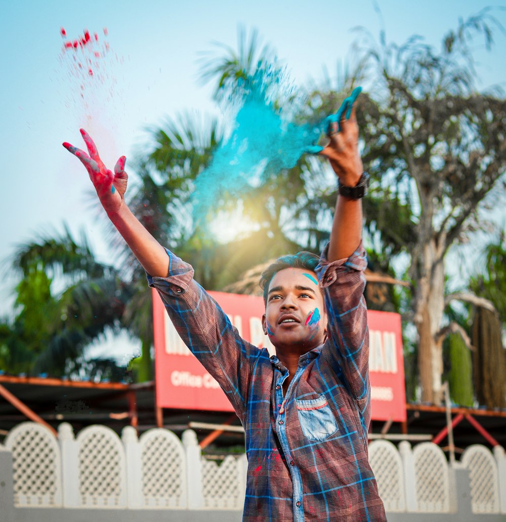 a man is throwing colored powder in the air