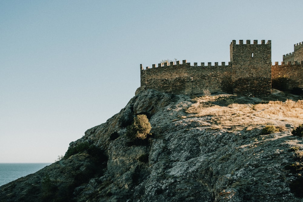 a castle sitting on top of a cliff next to the ocean