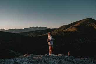 a woman standing on top of a mountain