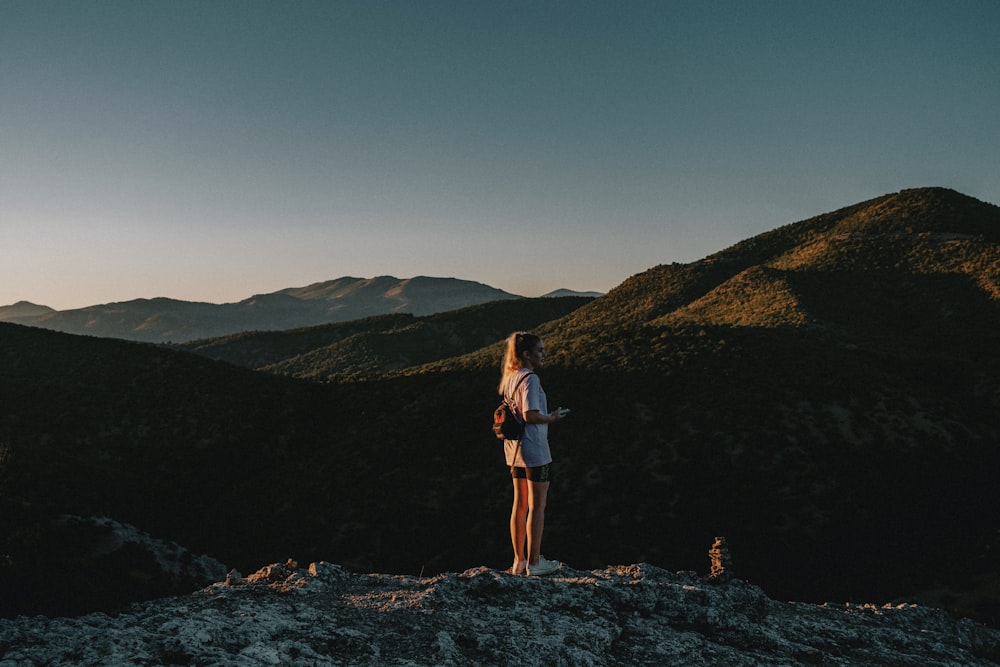 a woman standing on top of a mountain