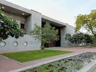 A serene green space surrounding a contemporary building.