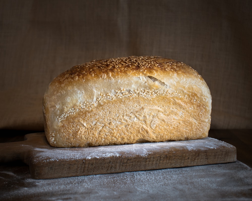 a loaf of bread sitting on top of a wooden cutting board