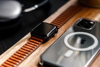 a couple of cell phones sitting on top of a wooden table
