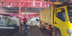 Workers inspecting goods in a warehouse filled with stacked crates ready for export.
