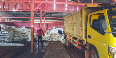 Stacked bags of Portland cement ready for shipment at a busy warehouse.