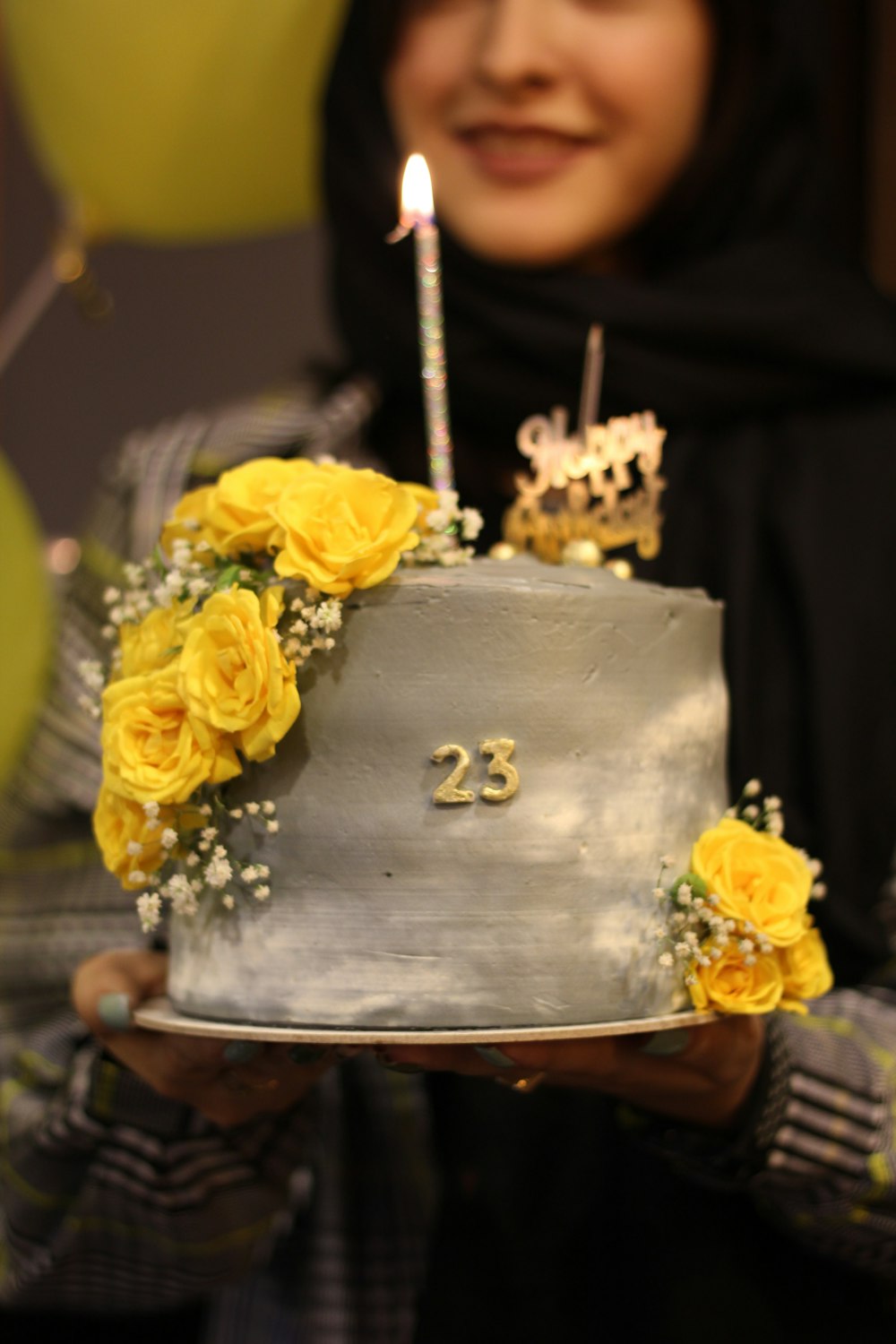 a woman holding a cake with a candle on it