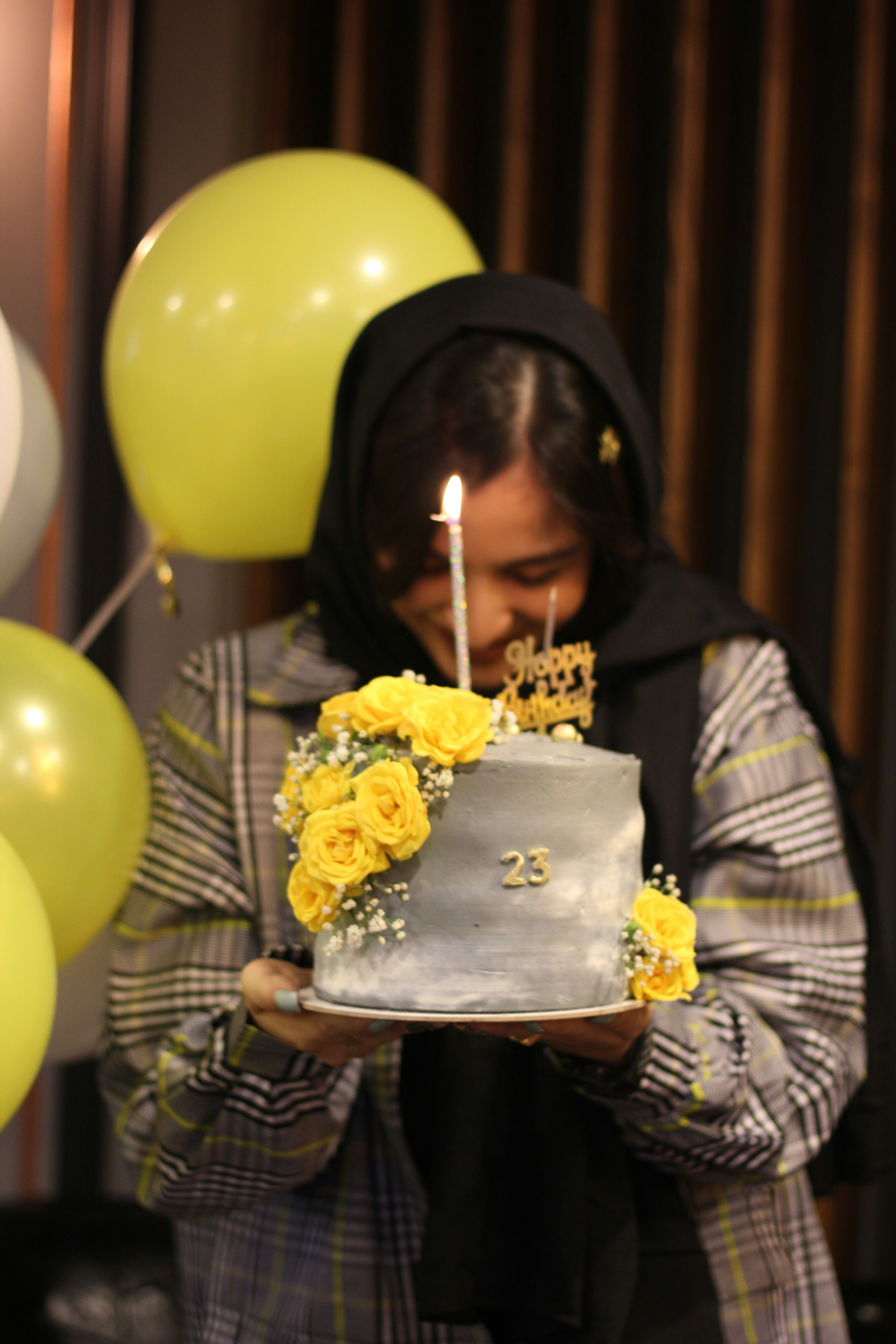a woman holding a cake with a candle on it