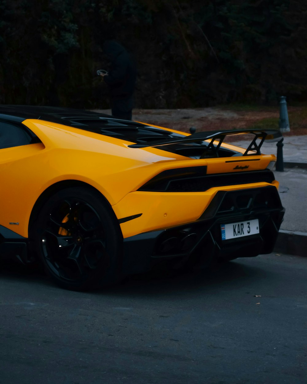 a yellow sports car parked on the side of the road