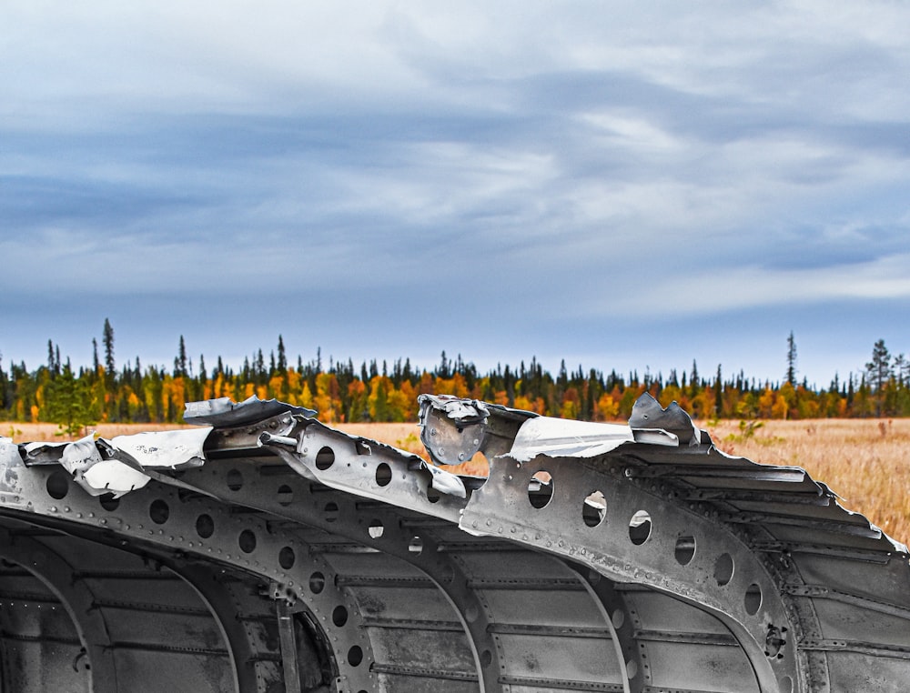 a row of metal structures sitting in a dry grass field